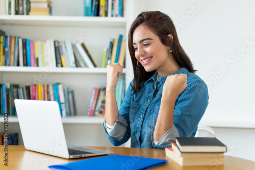 Junge Studentin hat Erfolg beim online shopping photo