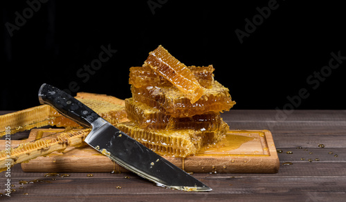 Organic rustic honey in combs lies on a cutting board. Copy space. The concept of beekeeping in agriculture.