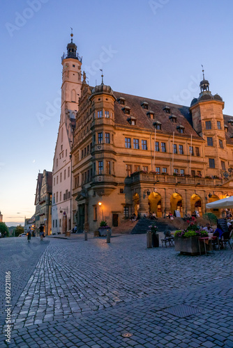 people enjoy a beautiful summer evening in the street cafes in the market square of Rothenburg