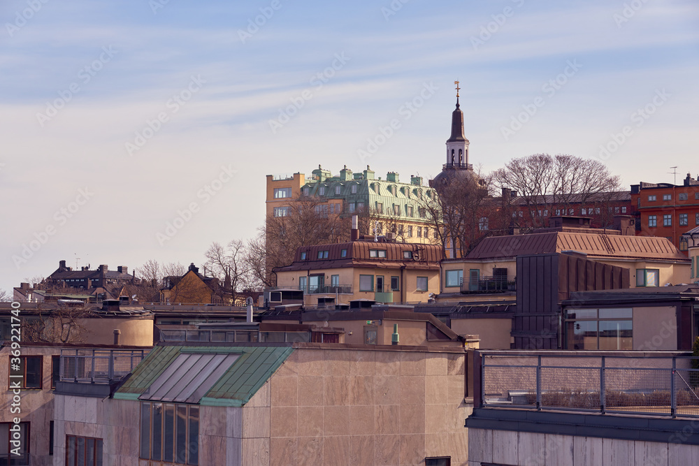 Roofs of Stockholm with clocktower of a cathedral.