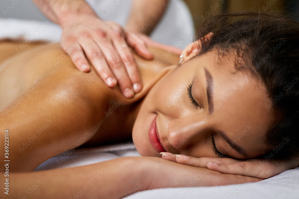 Close-up of a woman enjoying in back massage at the spa. Close-up of a woman enjoying in back massage at the spa.