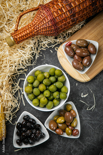 different types of olives on a dark concrete photo