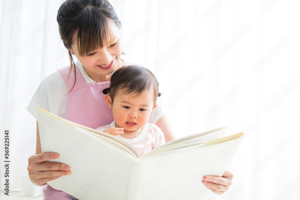 絵本の読み聞かせをする保育士 絵本の読み聞かせをする保育士