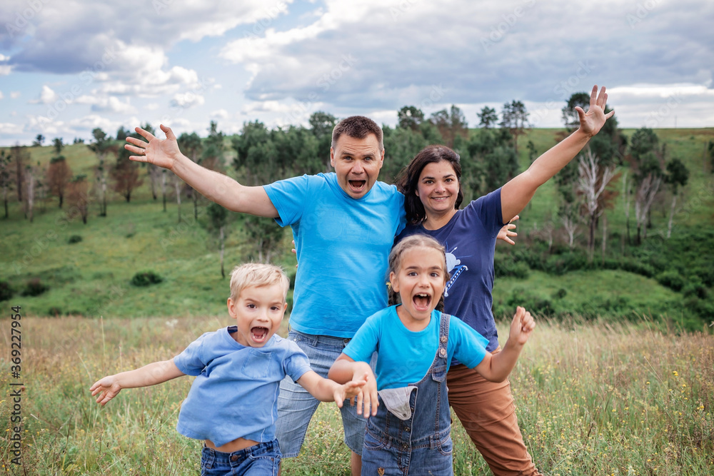 Fototapeta premium Crazy family portrait. Parents with two kids making selfie during local travel