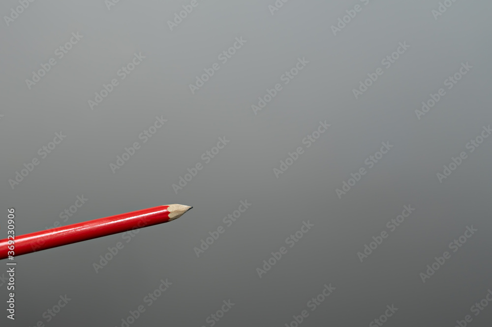 Red pencil on gray background Red pencil on gray background