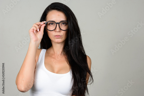 Portrait of beautiful woman with eyeglasses against white background