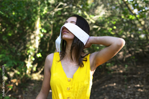 Woman taking off blindfold in forest. Environment concept.
