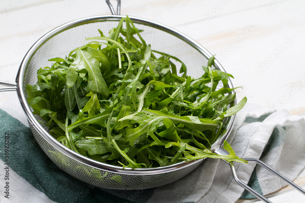 Washed arugula in a steel sieve Washed arugula in a steel sieve