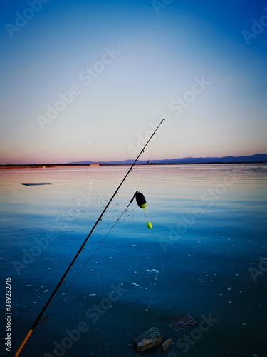 Sunset on the lake. Fishing rod in the foreground. Poland.