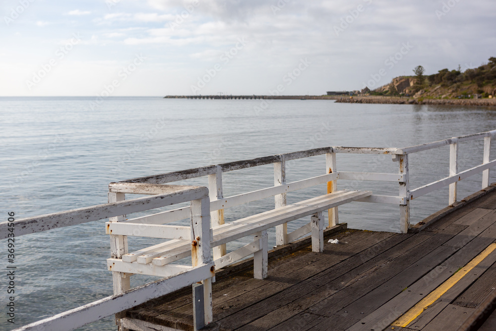 Fototapeta premium A bench seat on the Granite Island Causeway looking towards to granite island located in Victor Harbor South Australia on August 3 2020