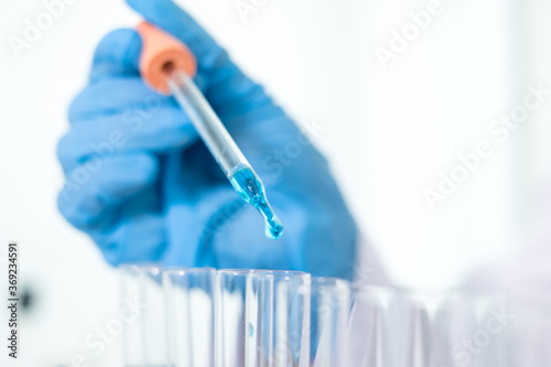 Medical scientists released a sample pipette into a test tube to analyze the virus in a chemical laboratory. Scientific research concepts