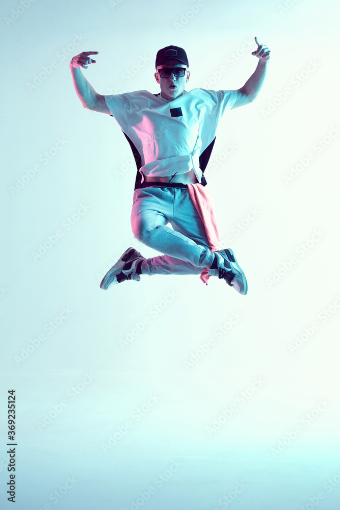 Breakdancer young man floating in the air in a jump in neon light. Dance school poster. Battle competition announcement