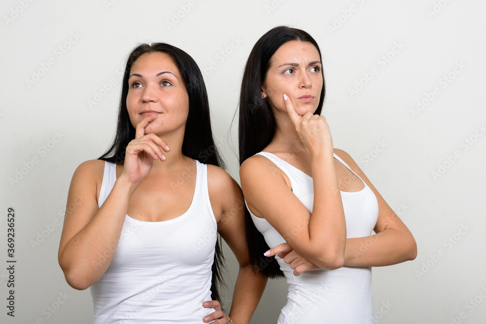 Portrait of two beautiful women thinking together Portrait of two beautiful women thinking together