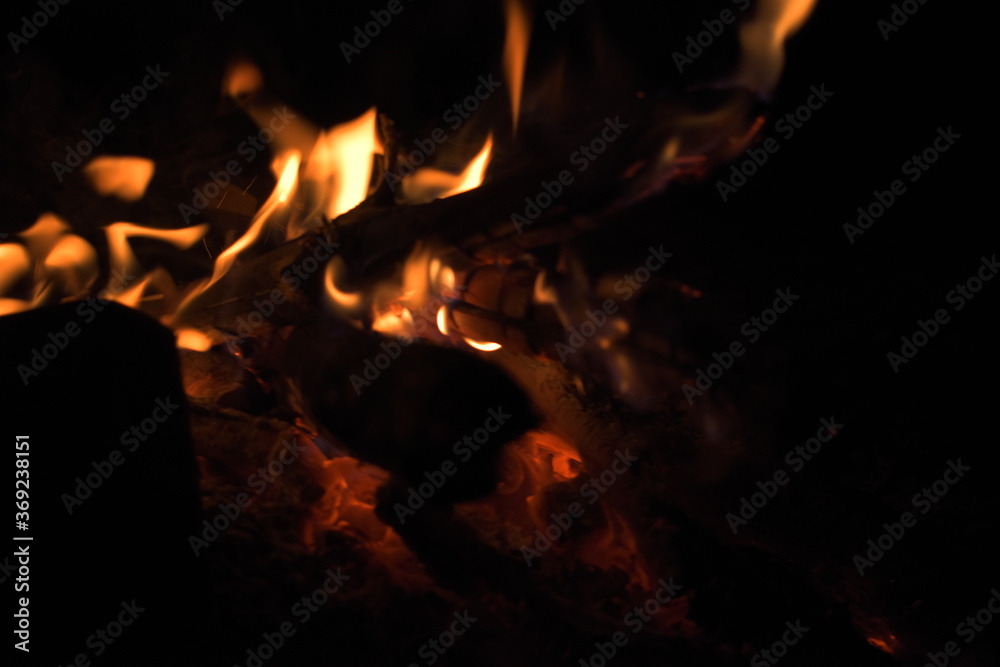 Burning wood at night. Campfire at touristic camp at nature in mountains. Flame amd fire sparks on dark abstract background. Cooking barbecue outdoor. Hellish fire element. Fuel, power and energy Burning wood at night. Campfire at touristic camp at nature in mountains. Flame amd fire sparks on dark abstract background. Cooking barbecue outdoor. Hellish fire element. Fuel, power and energy