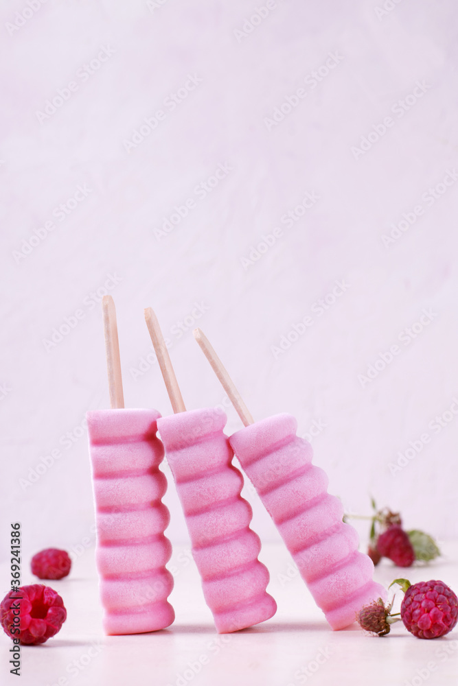 Three raspberry ice cream popsicles on the white table. Copy space Three raspberry ice cream popsicles on the white table. Copy space