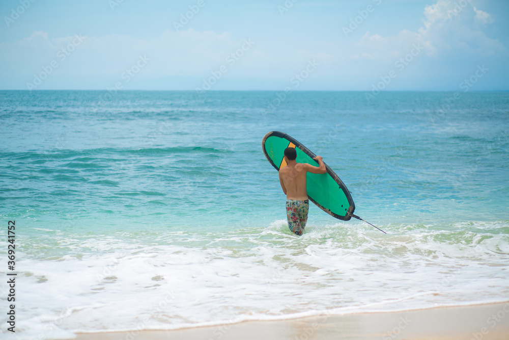 The guy is swimming on the surf board on the ocean. Healthy active lifestyle in summer vocation. The guy is swimming on the surf board on the ocean. Healthy active lifestyle in summer vocation.