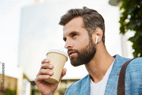 Young confident man listening to music