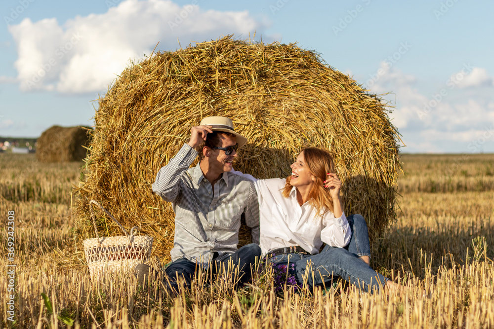 Portrait of lovers on hay background. Happy smiling couple in love during a picnic in field. Portrait of lovers on hay background. Happy smiling couple in love during a picnic in field.