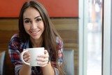 Portrait of young beautiful hipster woman at the coffee shop