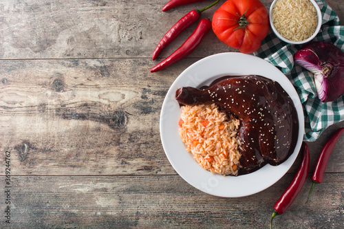 Traditional mole Poblano with rice in plate on wooden table.Top view. Copy space	 photo