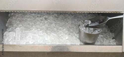 Ice scoop and ice bucket in the ice machine ready to serve