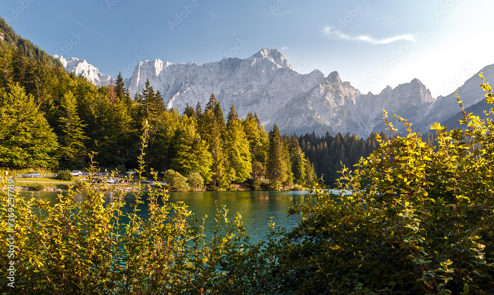 Scenic image of Fairytale lake Fusine during sunset. Picturesque landscape with lake, forest and majestic mount. Wonderful Autumn landscape. Picturesque view of nature. Amazing natural Background
