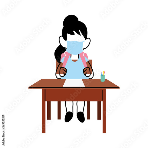 girl with face mask at school desk