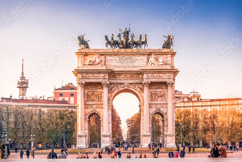 The Arch of Peace (Arco della Pace) in Piazza Sempione, Milan, at sunset, with people. Designed in neoclassical style by Luigi Cagnola in 19th century photo