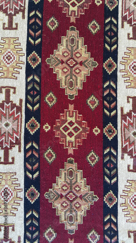 Fabric with Armenian pattern. Carpet detail with traditional ornaments and patterns. Embroidery is one of the oldest types of needlework. The old background. Vertical photo.