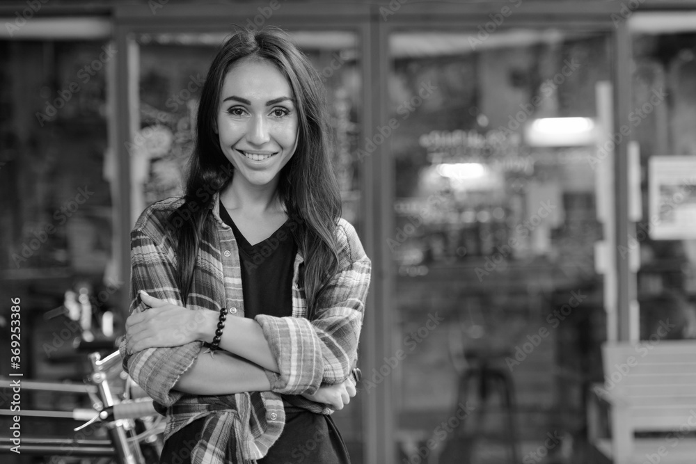 Young beautiful hipster woman at the coffee shop outdoors in black and white