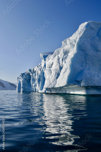 Edge of iceberg in antarctic ocean, blue sky and sun, melting ice, Antarctica © HWL Photos