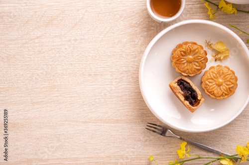 Mid-Autumn Festival holiday concept design of moon cake, mooncakes, tea set on bright wooden table with copy space, top view, flat lay, overhead shot