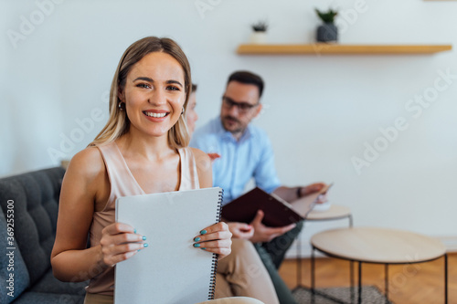 Portrait of a happy young businesswoman holding blank note pad.