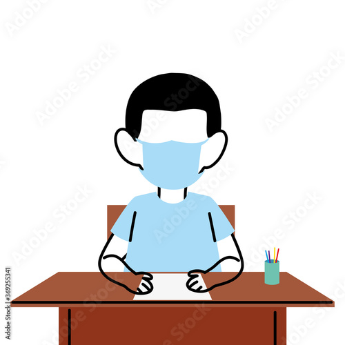 boy with face mask at school desk