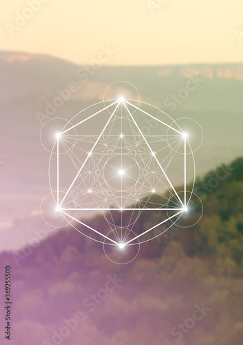 Merkaba sacred geometry spiritual new age futuristic illustration with interlocking circles, triangles and glowing particles in front of blurry natural photographic background