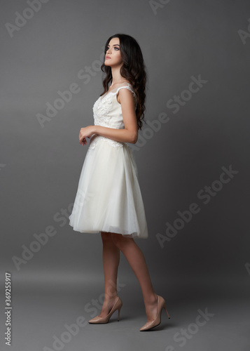 Beautiful bride on gray background. Portrait of a Bride in beautiful wedding dress. © Gecko Studio