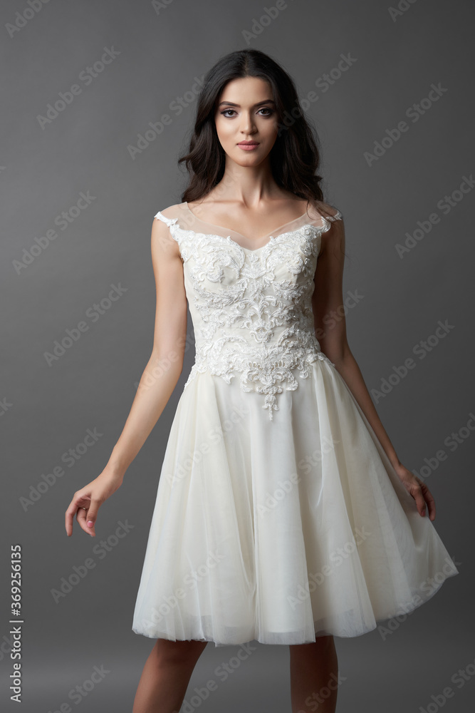 Beautiful bride on gray background. Portrait of a Bride in beautiful wedding dress.