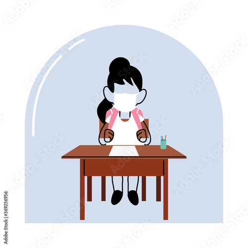 girl with face mask at school desk