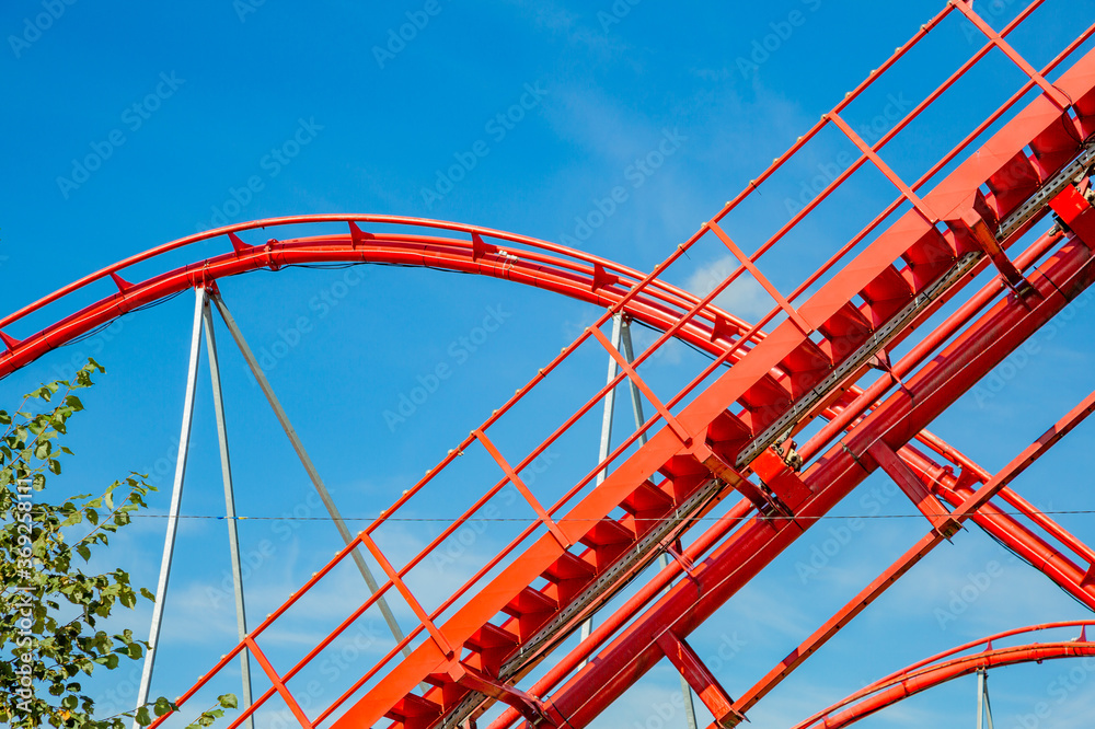 Roller coaster in an amusement park on a blue sky background on a sunny summer day Roller coaster in an amusement park on a blue sky background on a sunny summer day