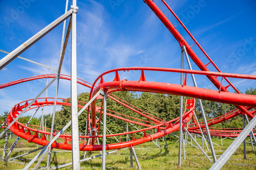 Roller coaster in an amusement park on a blue sky background on a sunny summer day