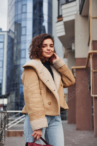 Young girl have a walk outdoors in the city near business building