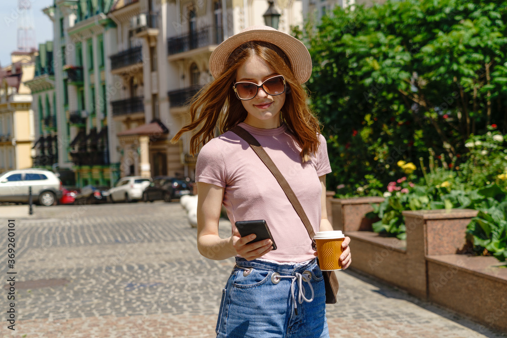 Beautiful Young Woman tourist with takeout coffee in the City Center talking on the phone