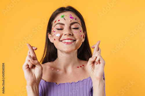Image of cheerful woman holding fingers crossed for good luck