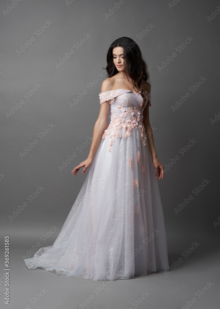 Beautiful bride on gray background. Portrait of a Bride in beautiful wedding dress.