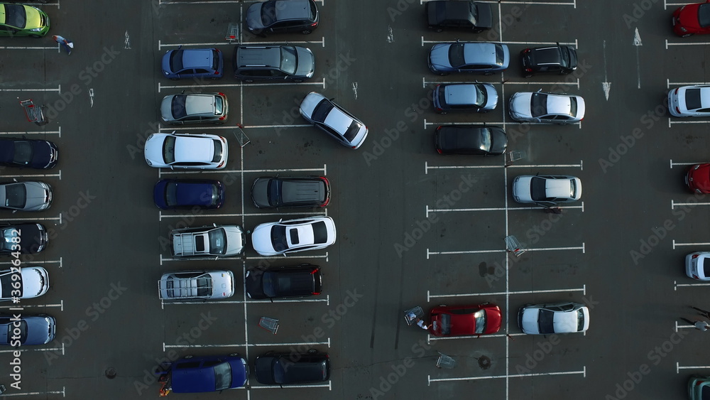 Drone footage cars parking at congested parking lots. people walking parking
