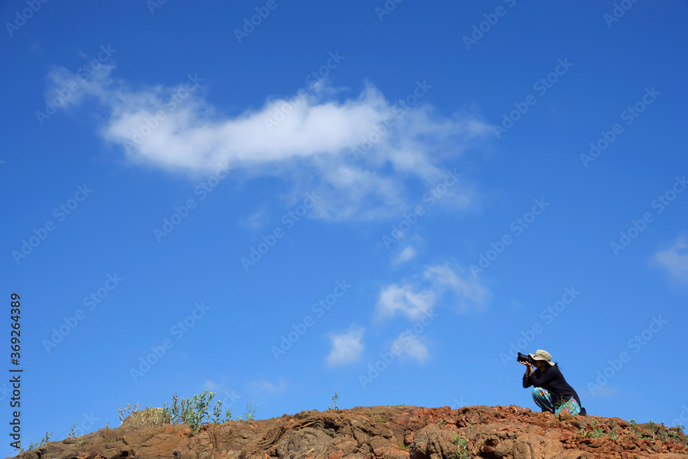 Lady photographer on top of mountain with clouds in blue sky. shot at Madhe ghat near Pune on 4 june 2017 Lady photographer on top of mountain with clouds in blue sky. shot at Madhe ghat near Pune on 4 june 2017