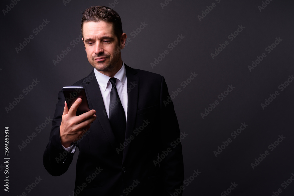 Portrait of handsome bearded businessman in suit using phone Portrait of handsome bearded businessman in suit using phone