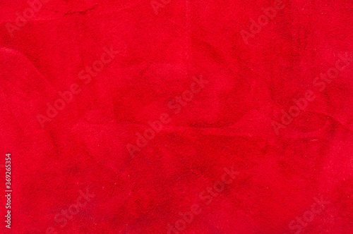 red matte background of suede fabric, closeup. Velvet texture of seamless wine leather. Felt material macro