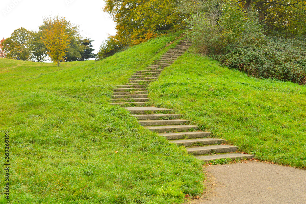 steps going uphill among green meadows in a park