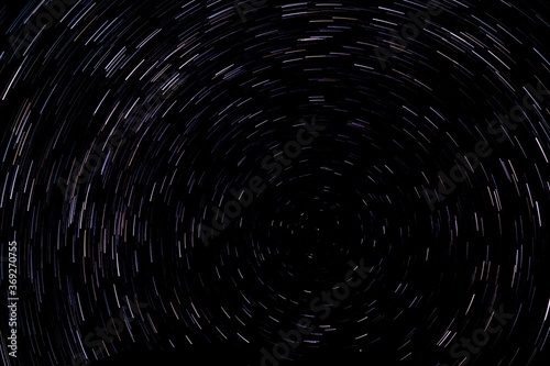Circular star light trails. Starry background. Night sky rotation. Deep space concept.